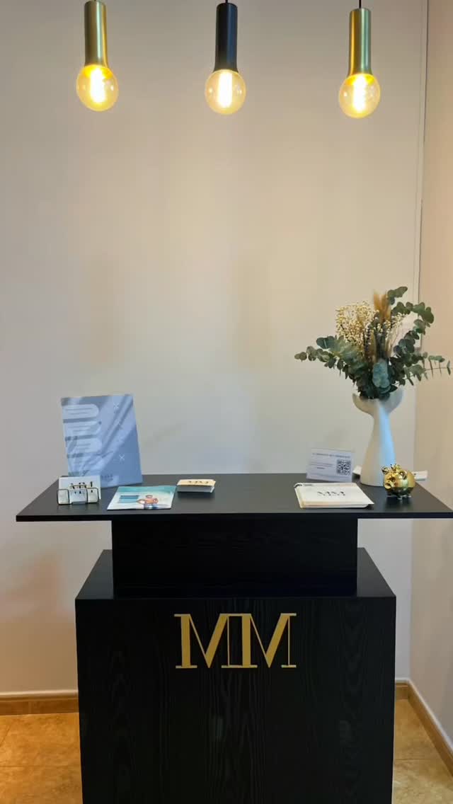 Recepción del centro Marta Montañez, con el mostrador negro y su monograma dorado